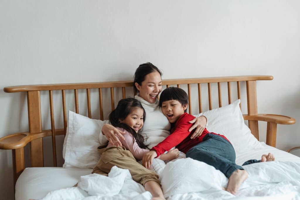 Mother and two Kids Laughing In Bed