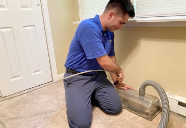 Man Cleaning Ducts From A Floor Vent