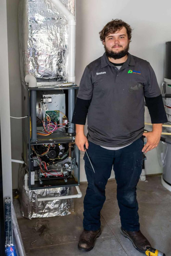 Employee Holding A Screw Driver In Front of An HVAC Unit-100kb